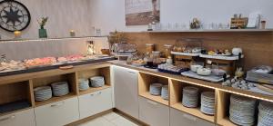 ein Buffet mit Tellern und Speisen zur Präsentation in der Unterkunft Hotel Am Deich in Norddeich