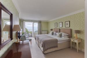 a bedroom with a large bed and a large window at Fermain Valley Hotel in St Peter Port