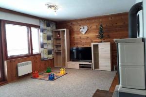 ein Wohnzimmer mit Holzwänden und einem TV in der Unterkunft Cottage IRENA in Giant Mountains in Černý Důl