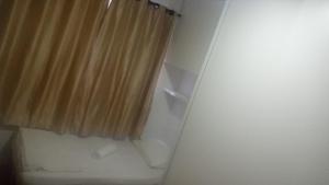 a bathroom with a shower curtain and a toilet at Recanto das Pimenteiras I in Teresópolis