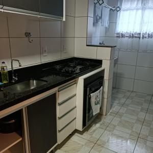 a kitchen with a stove top oven next to a sink at Recanto das Pimenteiras I in Teresópolis