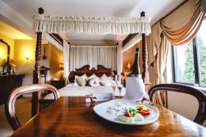 ein Schlafzimmer mit einem Bett und einem Tisch mit einem Teller Essen in der Unterkunft Aherlow House Hotel & Lodges in Aherlow