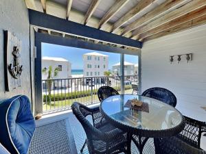 een patio met een tafel en stoelen op een balkon bij Seascape 204 in Orange Beach