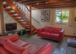 sala de estar con sofá rojo y escalera en Gwalia Falls en Aberporth