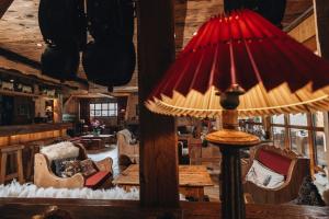 a red lamp in a living room with a table and chairs at Residence Hôtelière La Renardiere in Samoëns