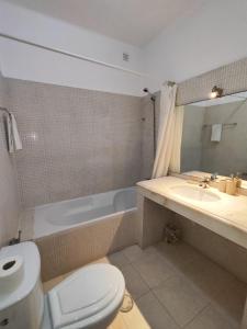 een badkamer met een toilet, een wastafel en een bad bij Vilas Marrocha in Porches
