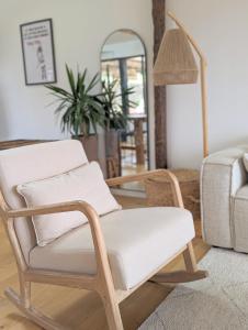 a living room with a chair and a mirror at Villa vue Mer -5 mn des plages - grand jardin-cuisine d'été- 4 chambres in Planguenoual