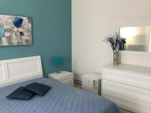 una camera blu con letto e specchio di B&B Villa Tania a Noto Marina