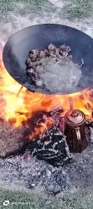 a grill with meat and a pot on fire at Petra downtown house in Wadi Musa