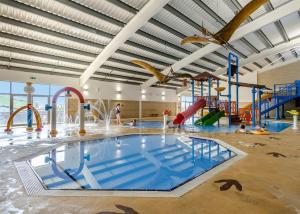 uma grande piscina interior num edifício com parque aquático em Freshwater Beach Holiday Park em Burton Bradstock