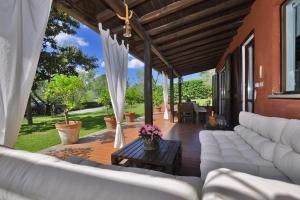 a patio with white couches and a table at Casale Pontarello - Happy Rentals in Vetralla