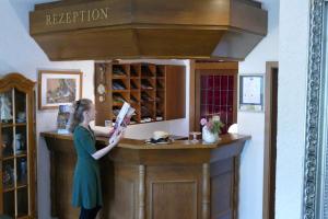 a woman standing at a counter in a wine shop at Zenner's Landhotel in Newel