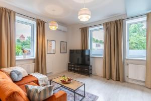 a living room with a couch and a tv at Apartment Quiet Street 11/1E in Oświęcim