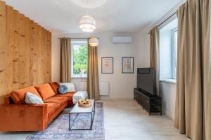 a living room with an orange couch and a tv at Apartment Quiet Street 11/1E in Oświęcim