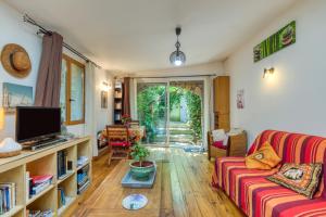 un soggiorno con un divano e una TV di Gîte Gaia a Poussan