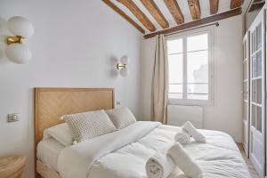a bedroom with a large white bed with towels on it at Eiffel Tower Apartment/Invalide by Studioprestige in Paris