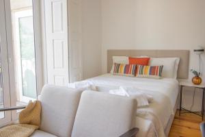 ポルトにあるFormosa79 Apartments by Guestifyの白いベッドルーム(ベッド1台、ソファ付)