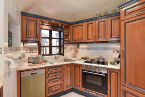 eine Küche mit Holzschränken und einer Spüle in der Unterkunft Roca del Mar 7 by VillaGranCanaria in Playa del Aguila + 24 Fotos