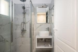 a white bathroom with a sink and a shower at Dallas Hotel in Svoronata