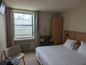 a hotel room with a bed and a large window at Chambres Breizh Café in Cancale