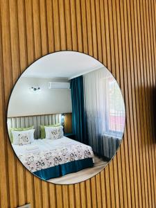 a bedroom with a round mirror on a wall at Family Hotel Neliya in Velingrad