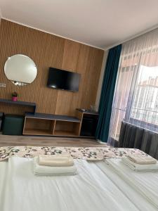 a bedroom with a bed with two towels on it at Family Hotel Neliya in Velingrad