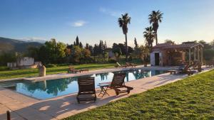 a swimming pool with two chairs and a gazebo at "MAS TRAMONTANE" Maison et Chambres d'hôtes avec vue sur le massif d'El Canigó in Ille-sur-Têt