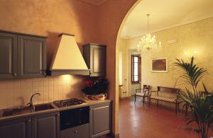 a kitchen with a sink and a stove top oven at B&B Palazzo Al Torrione 2 in San Gimignano