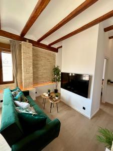 a living room with a green couch and a large television at Apartments & Boutique Meraki in Ontinyent