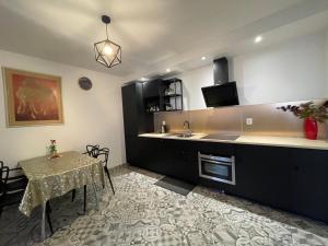 a kitchen with a table and a sink and a counter at APARTAMENT KRÓLEWSKI CENTRUM NIEPOŁOMICE in Niepołomice