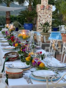 uma mesa longa com pratos e copos em Villa Neptunus em Ischia