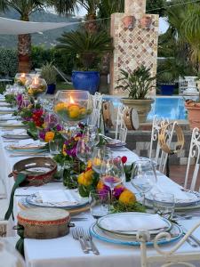 una mesa larga con platos y vasos. en Villa Neptunus, en Isquia