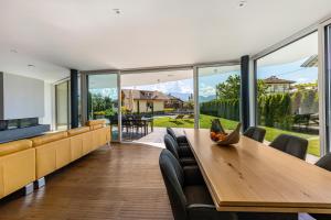 a dining room with a table and chairs and windows at Villa Aich in San Paolo