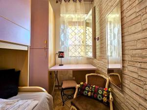 1 dormitorio con cama, escritorio y ventana en A due passi dal Mare e Stazione, en Ladispoli