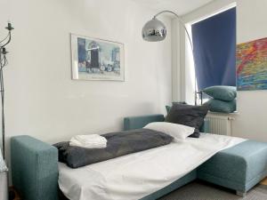 uma cama num quarto com uma cadeira azul em Gemütliches Apartment, Seenähe, WM, WLAN, Balkon em Markkleeberg