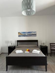 um quarto com uma cama com duas cadeiras e um quadro em Holiday Home Tarinuzza em Lipari