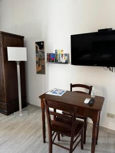 een kamer met een tafel en een flatscreen-tv bij Holiday Home Tarinuzza in Lipari