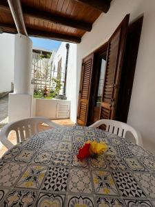 a dining room table with a black and yellow patterned table cloth at Holiday Home Tarinuzza in Lipari