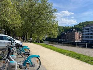 a blue bike parked on a sidewalk next to a street at Cosy suite La citadelle private duplex in Namur