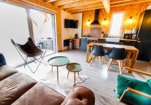 ein Wohnzimmer mit einem Sofa, Stühlen und einem Tisch in der Unterkunft Le petit Repaire de Sailhan, Ecolodges in Sailhan
