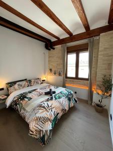 um quarto com uma cama e uma grande janela em Apartments & Boutique Meraki em Ontinyent