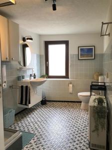 Un baño con lavabo, inodoro y ventana. en das rote Ferienhaus Terlinden, en Lieser