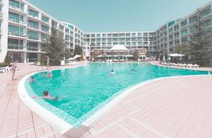 a large swimming pool with people in the water at Апартамент МеГи in Burgas +9 photos