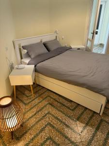 a bedroom with a large bed with a table and a stool at Αλμα - A Family boutique apartment at the city center in Kalamata