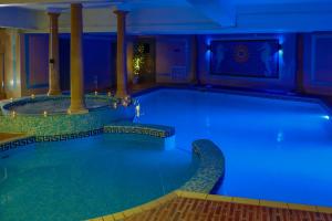 a large swimming pool with blue lighting in a hotel at Bournemouth West Cliff Hotel in Bournemouth