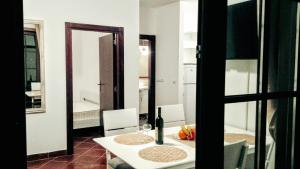 a dining room with a table with a bottle of wine at Apartments Boka Vista in Kamenari +29 photos