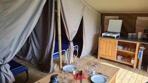 una habitación con una mesa y una tienda de campaña en Camping la Colline, en Virton