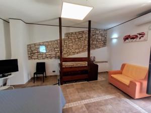 a living room with a couch and a tv at Antiche Mura Apartments "Nel Cuore della Puglia"bivani, cucina, terrazzo in Turi