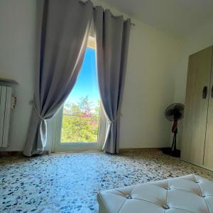 una camera con una grande finestra e un letto in una stanza di La Casetta del Borgo Antico a Campomarino