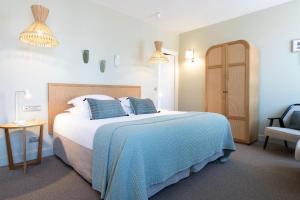 a bedroom with a large bed and a chair at Hôtel Cézanne Boutique-Hôtel in Aix-en-Provence